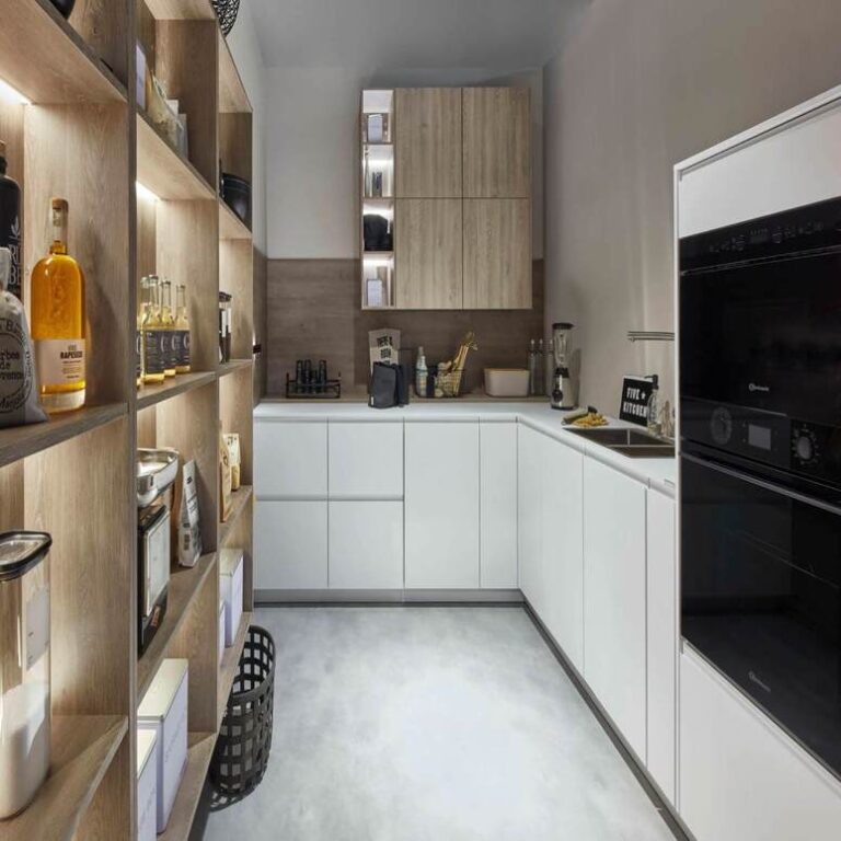 Moderne weiße Küche mit Hochschränken, Holzregal und schwarzen Einbaugeräten – Küche kaufen Münster